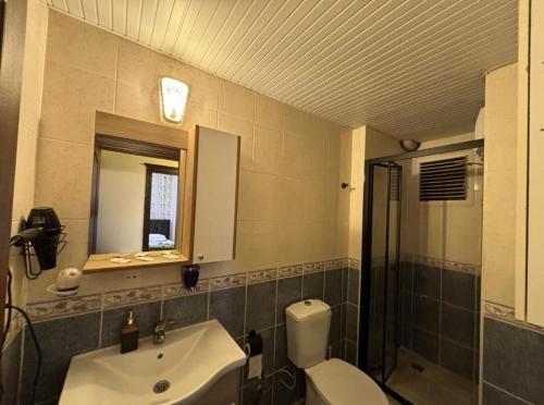 a bathroom with a sink and a toilet and a mirror at Fener Konaklama in Antalya