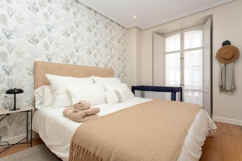 een slaapkamer met een bed met handdoeken erop bij Apartamento de La Gandara in Llanes