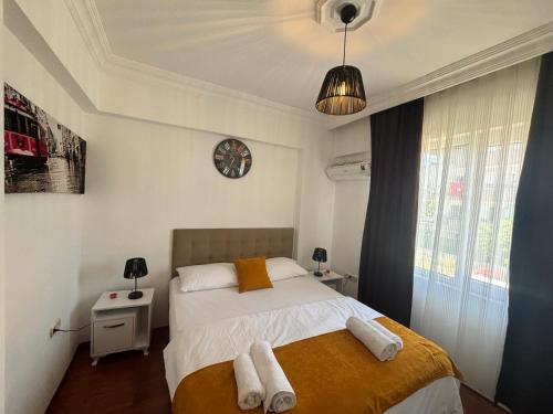 a bedroom with a bed and a clock on the wall at Fener Konaklama in Antalya