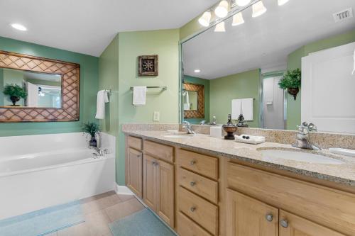 a bathroom with two sinks and a bath tub and a tubermott at Beachfront Bliss Luxe 3BR Condo at Marisol Complex in Panama City Beach