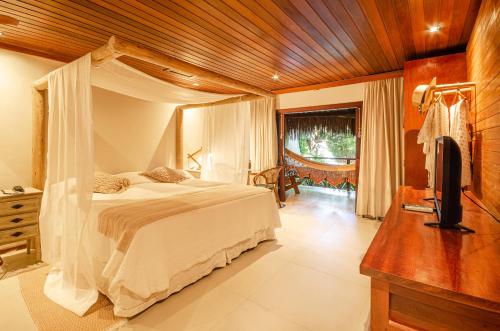 a bedroom with a bed and a tv in a room at Hotel Ponta do Madeiro in Pipa