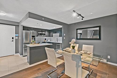 a kitchen and dining room with a table and chairs at Stunning 3 Bedroom Duplex in the heart of Yaletown! Sleeps 8 in Vancouver