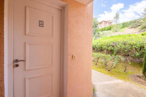 une porte ouverte menant à une maison avec une allée. dans l'établissement Résidence le Village de Cap Esterel - maeva Home - Appartement 2 Pièces 5 Personnes - Vue mer - Sélection MAE-5414, à Saint-Raphaël