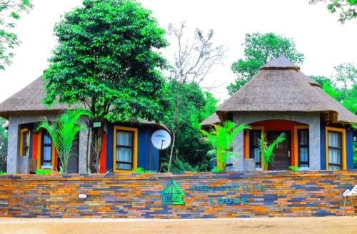 a small house with a clock on a brick wall at Elias Nefale Eco Estate in Mitxetweni