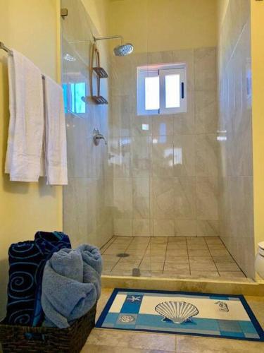 a bathroom with a shower and a basket of towels at 3B Cerritos Beach Condo, Lrg Pool, Baja Sur in San Carlos