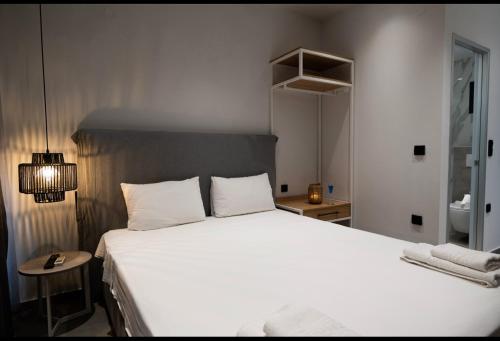 a bedroom with a large white bed with two pillows at Studio Theano in Kallithea Halkidikis