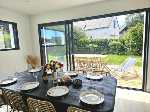 - une table à manger avec une nappe noire et des chaises dans l'établissement Villa avec jardin,proche port du Crouesty 500 m et des plages 2km, à Arzon