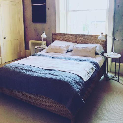 a large bed in a bedroom with two tables at Norfolk House Hosted by The Scarlet Hen in Huddersfield