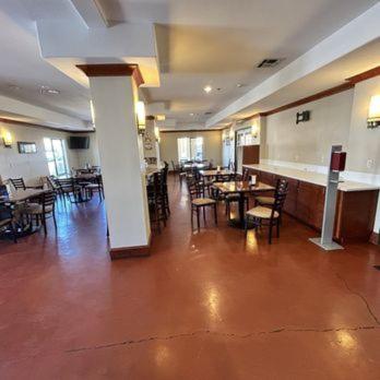 a dining room with tables and chairs in a restaurant at Oasis Inn & Suites 29 Palms Hotel Joshua Tree National Park in Twentynine Palms