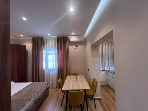 a room with a bed and a table and chairs at Vila Magis in Vlorë