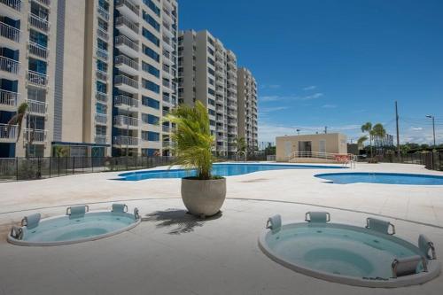 una piscina con una maceta y edificios en Apto completo Pto Azul Club House Ven a Descansar en Ricaurte