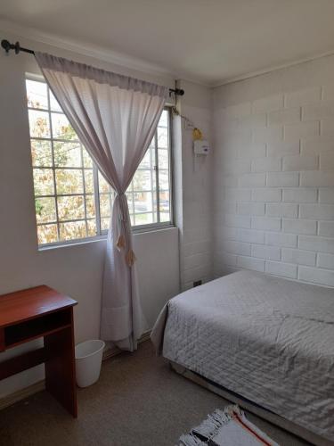 Schlafzimmer mit einem Bett und einem Fenster in der Unterkunft Nova Vida in Santiago
