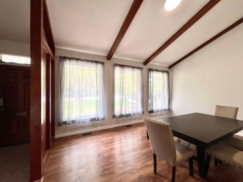 a dining room with a table and chairs and windows at ViHome-Queen bedroom near Don Mills Dvp & 401 in Toronto