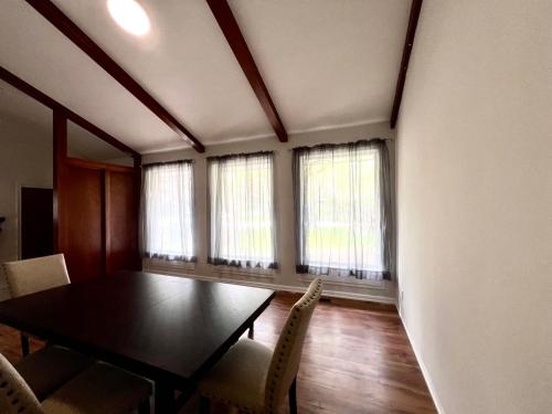 a dining room with a table and chairs and windows at ViHome-Queen bedroom near Don Mills Dvp & 401 in Toronto