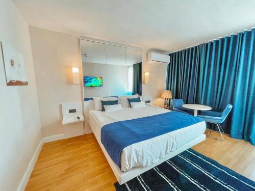 een slaapkamer met een groot bed en blauwe gordijnen bij Aparthotel in Batoemi