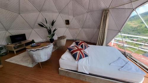 a bedroom with a tent with a bed and a desk at Syameen's Glamping Dome in Kundasang