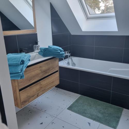 une salle de bain avec un lavabo et une baignoire dans l'établissement Villa avec jardin,proche port du Crouesty 500 m et des plages 2km, à Arzon