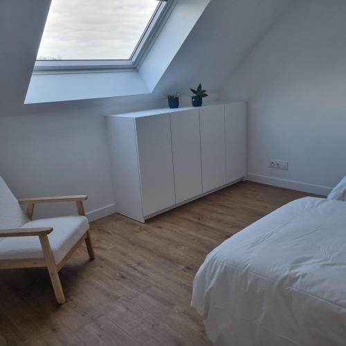 une chambre blanche avec un lit et une fenêtre dans l'établissement Villa avec jardin,proche port du Crouesty 500 m et des plages 2km, à Arzon