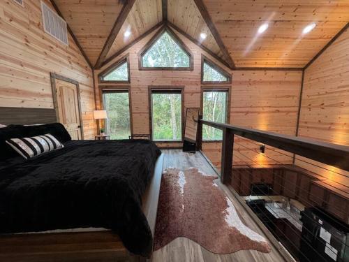sypialnia z łóżkiem w drewnianym domku w obiekcie The Moonlight Dream Cabin! w mieście Broken Bow