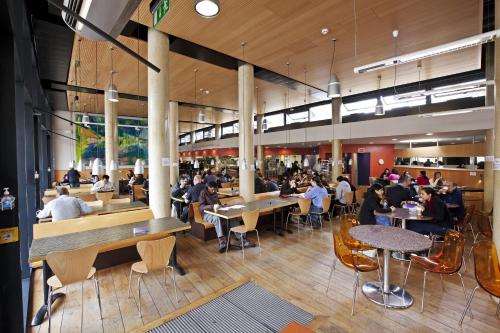 a group of people sitting at tables in a restaurant at Stay QM in London