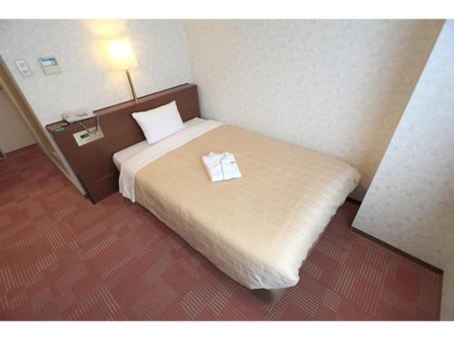 a hotel room with a bed with two towels on it at Kumegawa Wing Hotel - Vacation STAY 62973v in Higashi-murayama