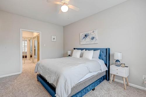 um quarto com uma cama azul e uma ventoinha de tecto em Cozy Modern Apartment with patio and pool. em Houston