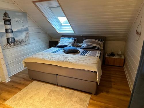 Un dormitorio con una cama en una habitación con ventana. en Ferienhaus Wiesenstrasse, en Neuhaus an der Oste