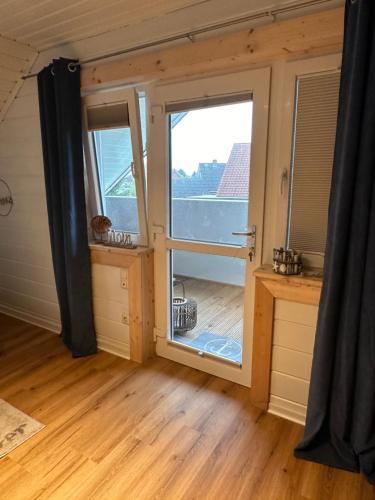 ein Zimmer mit einem großen Fenster in einem winzigen Haus in der Unterkunft Ferienhaus Wiesenstrasse in Neuhaus an der Oste