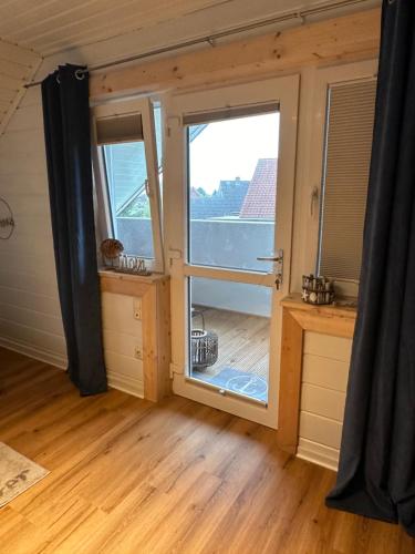Habitación con ventana grande en una casa pequeña en Ferienhaus Wiesenstrasse, en Neuhaus an der Oste
