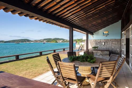 un patio con mesa, sillas y el océano en Most Gorgeous Home in Buzios VILLA ATLANTIS en Armacao dos Buzios