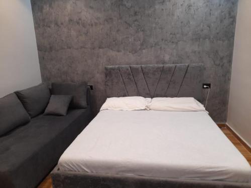 a bed and a couch in a room at Vila Magis in Vlorë
