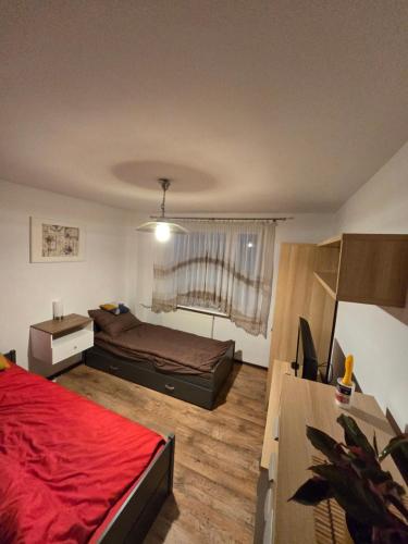 a bedroom with a bed with a red blanket at Apartament Sosnowiec in Sosnowiec