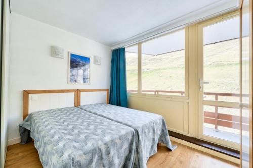 une chambre avec un lit et une grande fenêtre dans l'établissement Résidence Le Montana - maeva Home - 2 pièces 6 Personnes - Sélection MAE-9723, à La Mongie