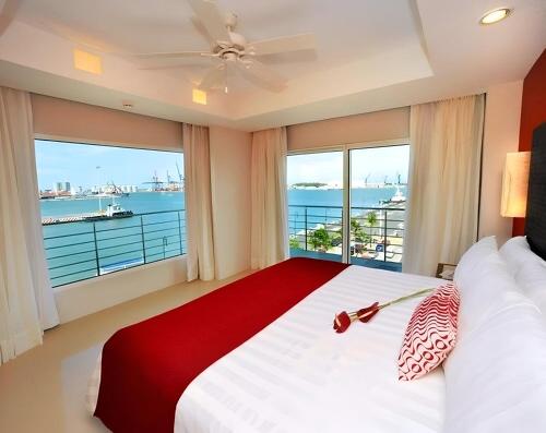 a bedroom with a large bed with a large window at Emporio Veracruz in Veracruz