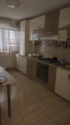 cocina con armarios blancos y fogones en Cris confort, en Fălticeni