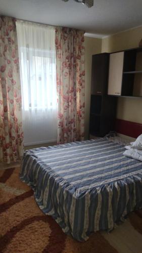 1 dormitorio con 1 cama con manta azul y blanca en Cris confort, en Fălticeni