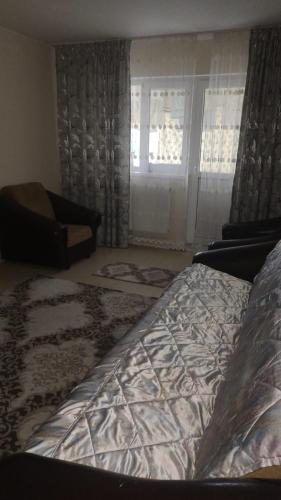 1 dormitorio con cama, sofá y ventana en Cris confort, en Fălticeni