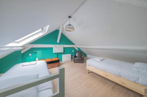 um quarto no sótão com 2 camas e uma cadeira em Le Royaume - Parking em Reims