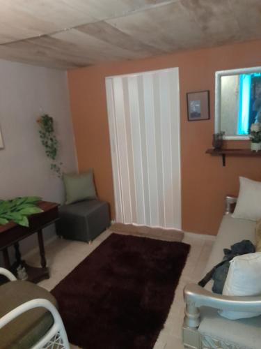 ein Wohnzimmer mit einem Sofa und einem Stuhl in der Unterkunft Nido de Amor in Pantoja
