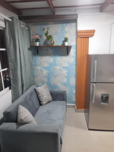 ein Wohnzimmer mit einem Sofa und einem Kühlschrank in der Unterkunft Nido de Amor in Pantoja