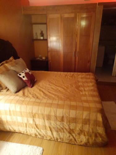 1 dormitorio con 1 cama grande y armario de madera en Nido de Amor, en Pantoja