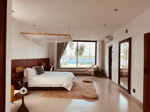 Villa Luasah في Vila Praia Do Bilene: غرفة نوم بسرير ونافذة كبيرة