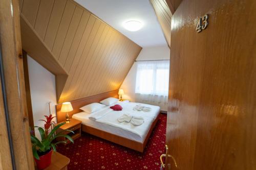 a hotel room with a bed with white sheets at Garden Resort by Cota 1200 in Predeal