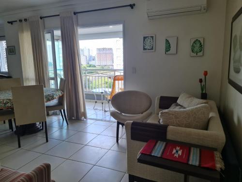 a living room with a couch and a table at Apartamento Aconchegante in Ribeirão Preto