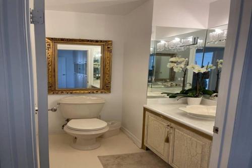 y baño con aseo, lavabo y espejo. en 3 Bd Beverly Hills House, en Los Ángeles