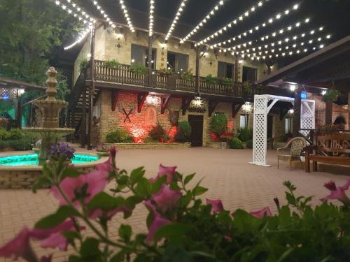 a courtyard with a fountain and a building with lights at Curtea Domneasca in Cricova