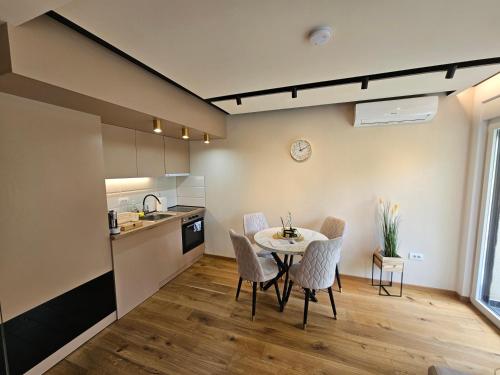a kitchen and dining room with a table and chairs at PREMIUM APARTMAN ELENI ROOMS,oaza mira i tisine u centru Vrnjacke banje in Vrnjačka Banja