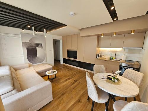 a living room with a couch and a table at PREMIUM APARTMAN ELENI ROOMS,oaza mira i tisine u centru Vrnjacke banje in Vrnjačka Banja