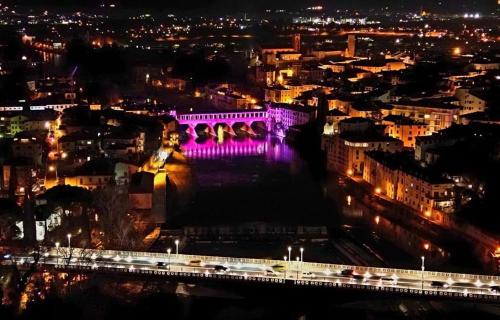 un pont avec des lumières violettes sur une ville la nuit dans l'établissement HEATHER'S HOME, à Bassano del Grappa