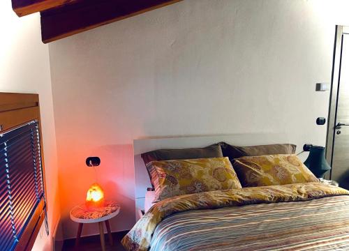 1 dormitorio con 1 cama y 1 mesa con lámpara en La Sellerie, en Nus